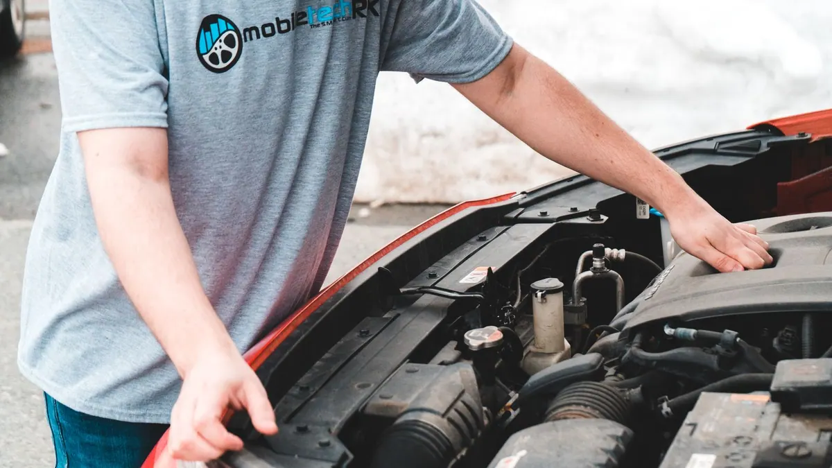 Homme inspectant le moteur de sa voiture en panne